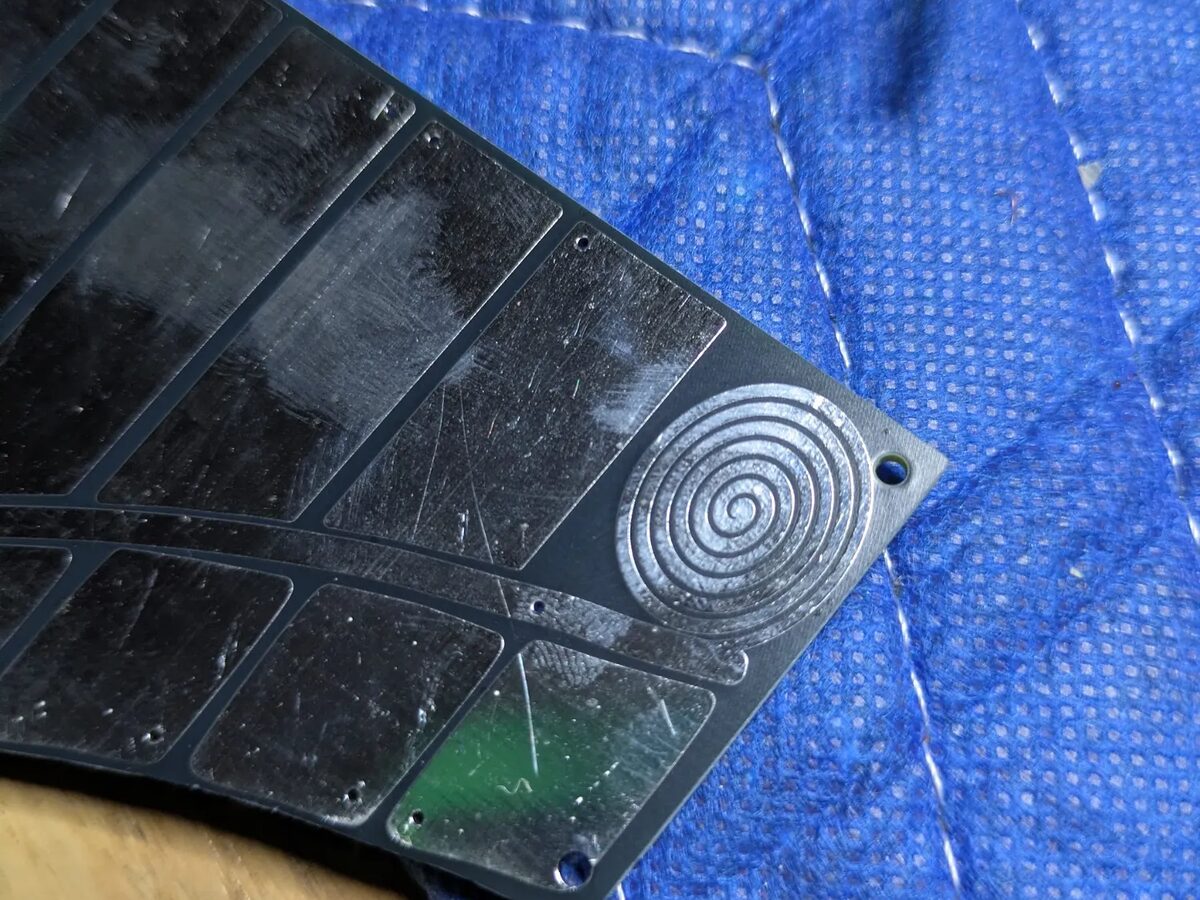Close-up of an OM-84 touchplate: black board with bare metal touch pads and a spiral touch-point